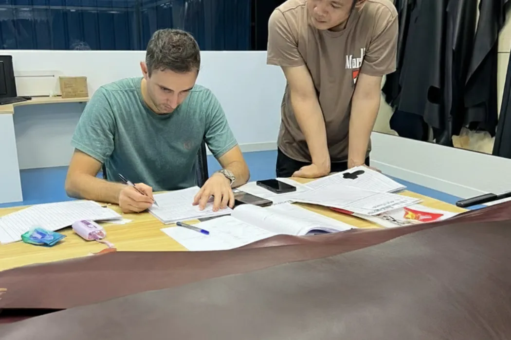 a brand manager or designer looking at different leather swatches, deciding between veg tan and chrome tan.