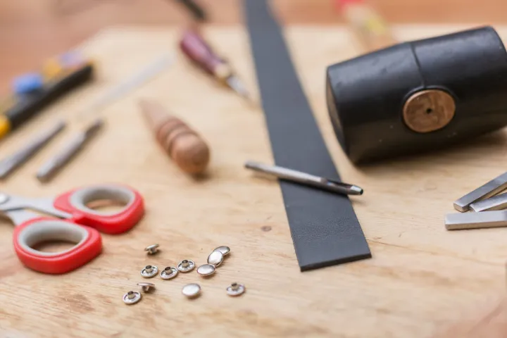 a comparison showing hand tools for belt making alongside industrial machinery.
